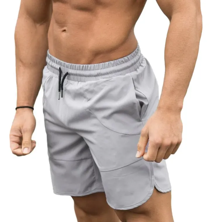 Light grey gym shorts with a zip pocket and drawcord waistband worn by a model, custom gym shorts manufacturing, Wears For You, Sialkot Pakistan