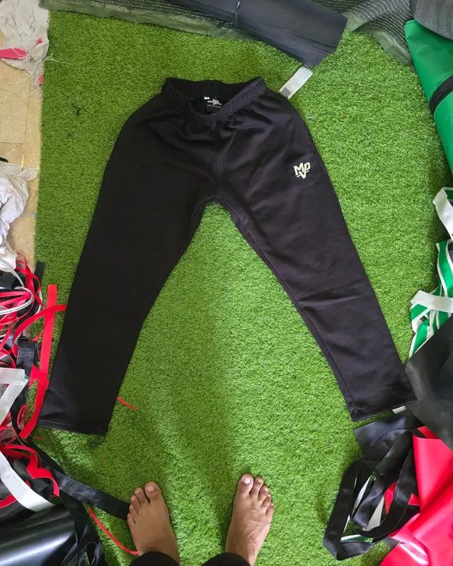 Black tapered joggers on the factory turf backdrop, custom sportswear, Wears For You, Sialkot Pakistan