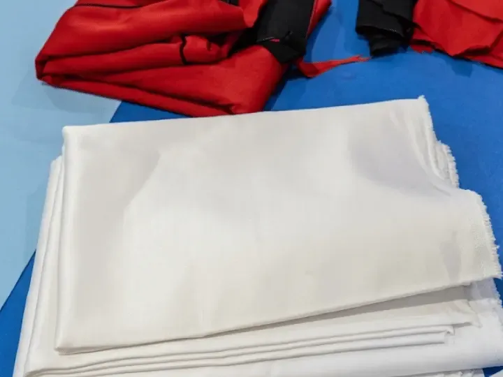 Sourced satin and jersey fabric staged before cutting, fabric sourcing for OEM clothing manufacturing, Wears For You, Sialkot Pakistan