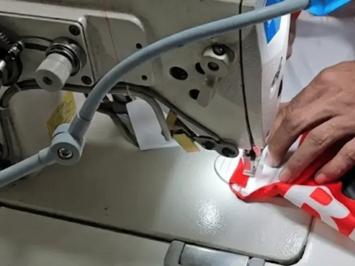 Machinist stitching a custom garment on an industrial sewing machine, low MOQ clothing manufacturing, Wears For You, Sialkot Pakistan