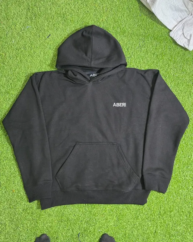 Black oversized hoodie on the factory turf backdrop, custom streetwear, Wears For You, Sialkot Pakistan