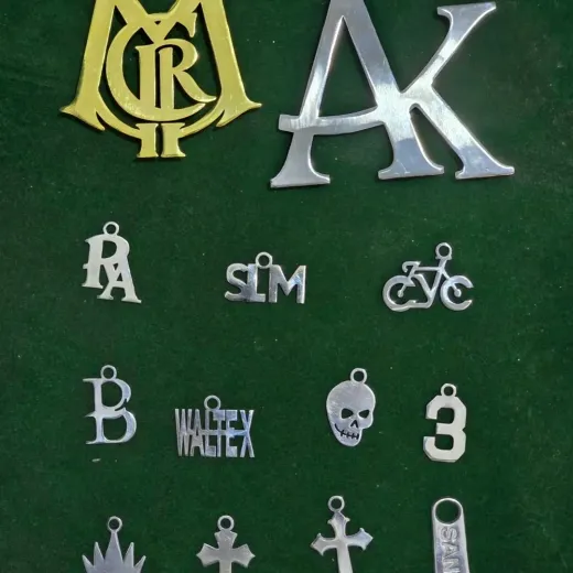 Brass and polished steel logo plates shown with a full set of cut metal charms, custom metal hardware, Wears For You, Sialkot Pakistan