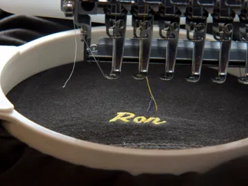 Embroidery machine stitching a custom logo onto a garment, custom embroidery, Wears For You, Sialkot Pakistan